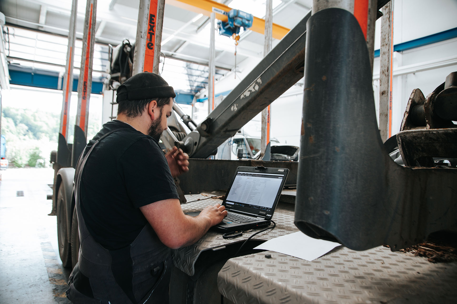Mechaniker arbeitet am Laptop in Werkstatt