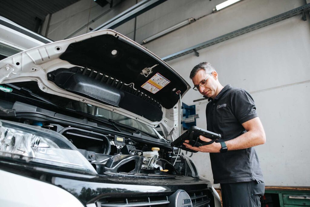 Mechaniker überprüft Fahrzeugtechnik.