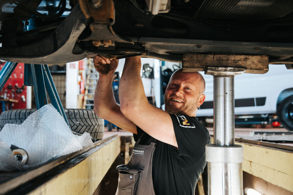 Mechaniker arbeitet unter einem Auto.