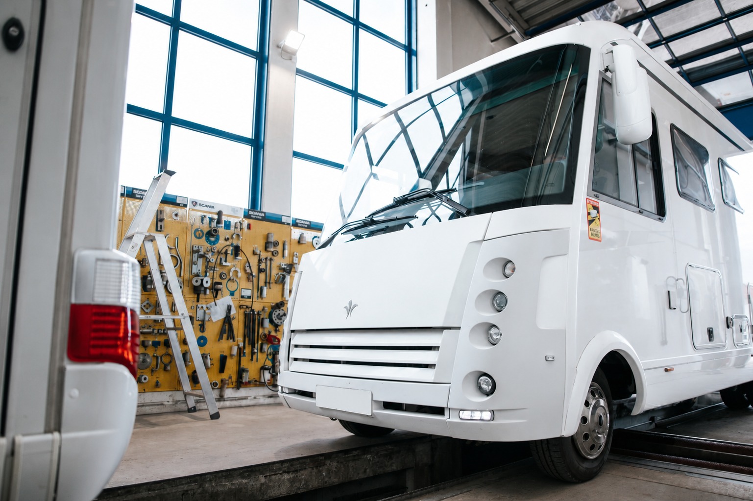 Weißes Wohnmobil in Werkstatt.